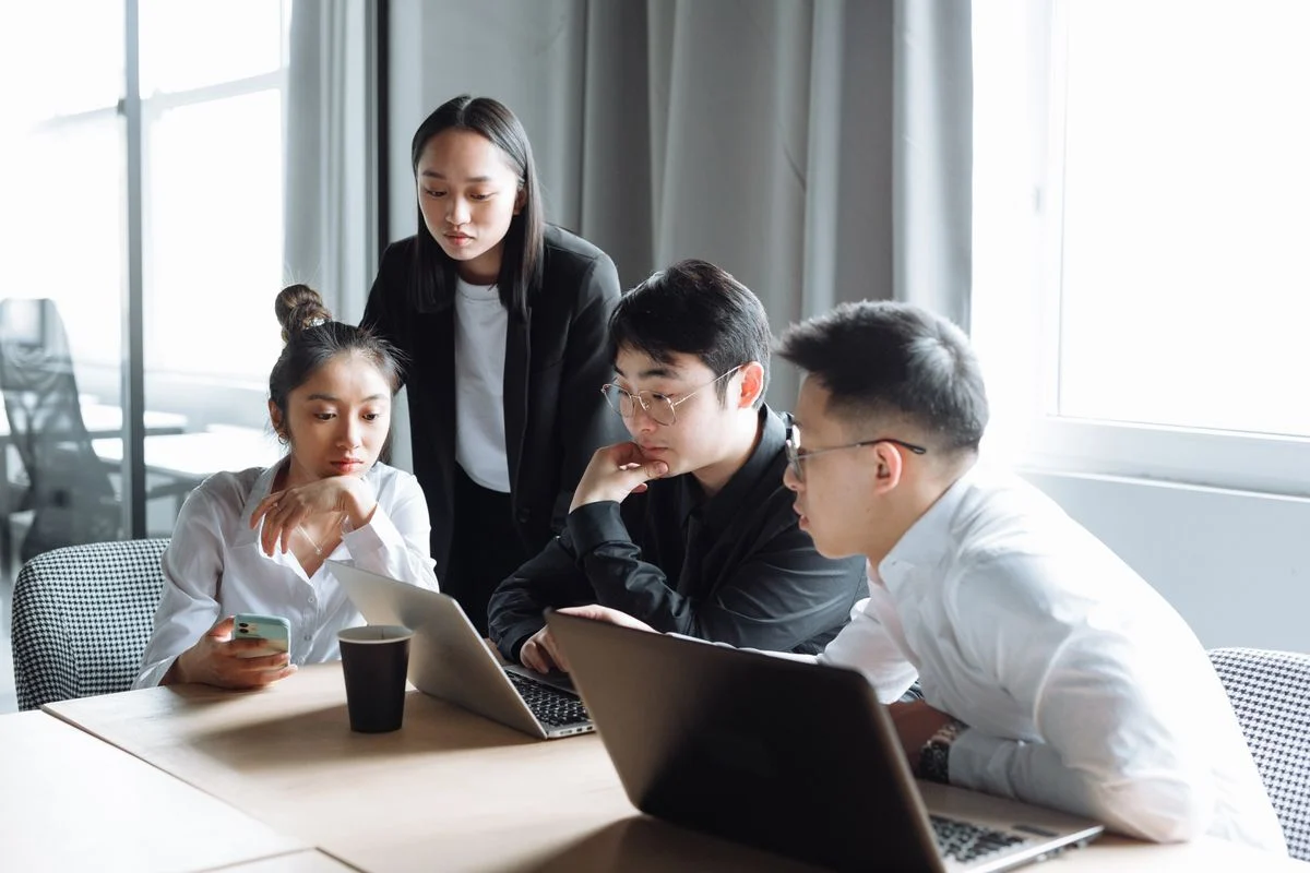 Professionals collaborating around a laptop — stock photo